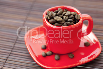 cup and saucer and coffee beans on a bamboo mat