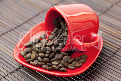 cup and saucer and coffee beans on a bamboo mat