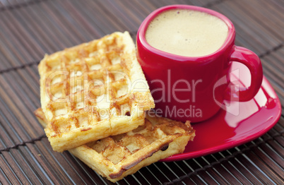 cup of cappuccino wafers on a bamboo mat