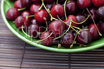 cherry in plate on a bamboo mat