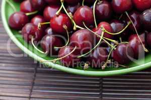 cherry in plate on a bamboo mat