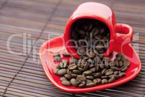 cup and saucer and coffee beans on a bamboo mat