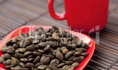 cup and saucer and coffee beans on a bamboo mat