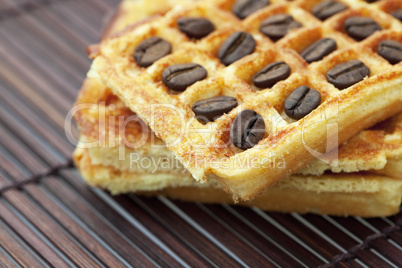 waffles and coffee beans on a bamboo mat