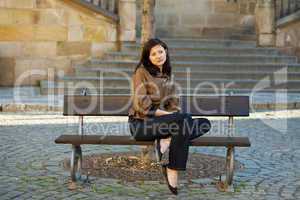 beautiful young woman sitting on a bench