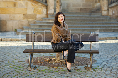 beautiful young woman sitting on a bench