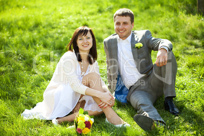 just married in a flowering garden sitting on the grass