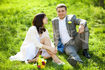 just married in a flowering garden sitting on the grass