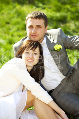 just married in a flowering garden sitting on the grass