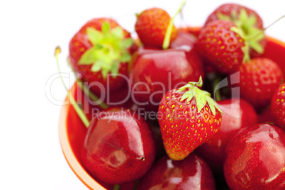 cherries and strawberries in a bowl isolated on white