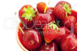 cherries and strawberries in a bowl isolated on white