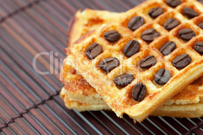 waffles and coffee beans on a bamboo mat