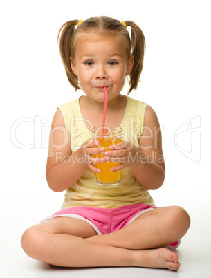 Little girl drinks orange juice