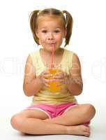 Little girl drinks orange juice