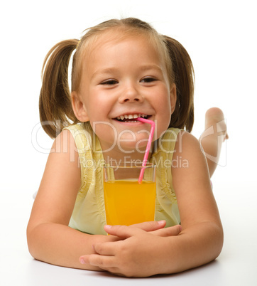 Little girl drinks orange juice