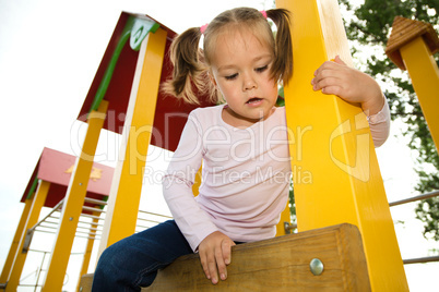 Little girl is playing in playground