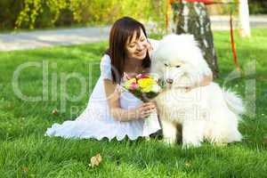Bride with dog Samoyed sitting on the grass