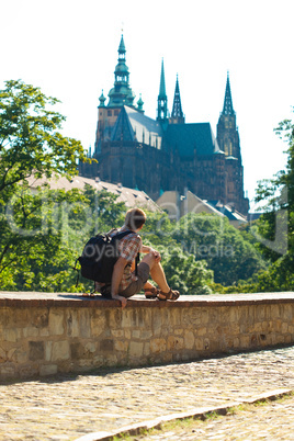 man sitting on a background of St. Vitus Cathedral in Prague