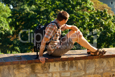 man sitting on a background of green foliage in Prague
