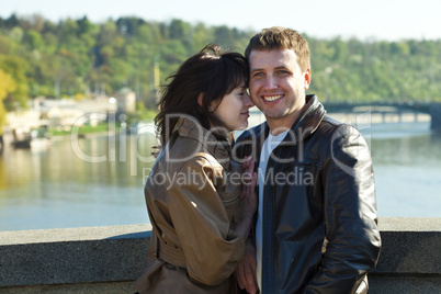 young couple on a bridge on the river