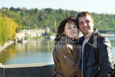 young couple on a bridge on the river