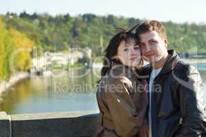 young couple on a bridge on the river