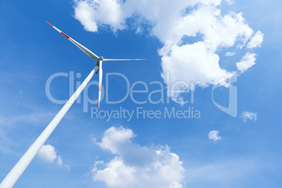 Modern wind energy turbine power station under blue sunny sky with many clouds