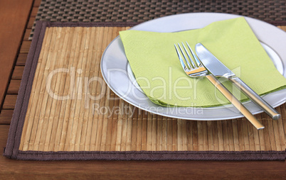 Teller mit Besteck auf Holztisch