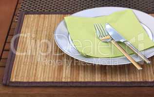 Teller mit Besteck auf Holztisch