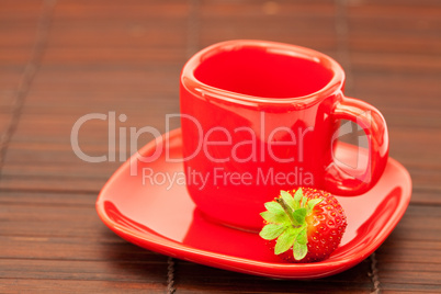 Cup and saucer and strawberries on a bamboo mat