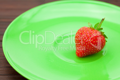 Strawberries and a plate on a bamboo mat