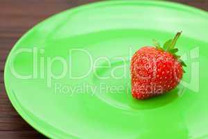 Strawberries and a plate on a bamboo mat
