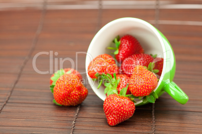 Cup  and strawberries on a bamboo mat