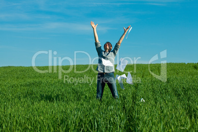 young man throwing a paper in the green field