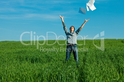 young man throwing a paper in the green field