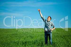 young man throwing a paper in the green field