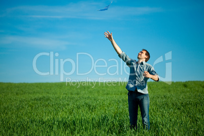 young man throwing a paper in the green field young man throwing a paper in the green field