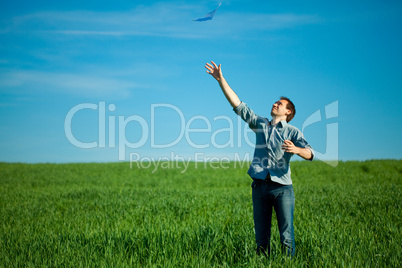 young man throwing a paper in the green field