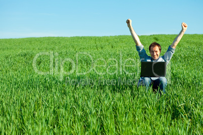 young man using laptop in the field