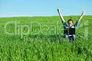 young man using laptop in the field