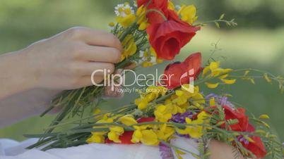 Young woman makes bouquet on nature in forest