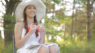 Young woman drawing, resting on nature