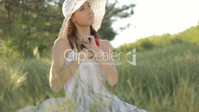 Young woman in white hat resting on nature in forest