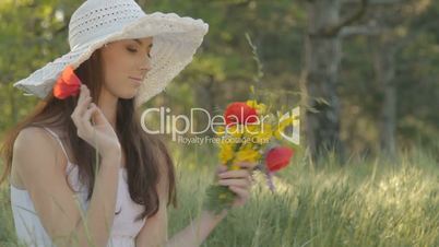 Young woman with bouquet resting on nature in forest