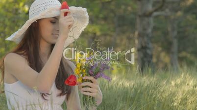 Young woman forming bouquet of wild flowers on nature