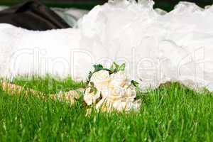 bridal bouquet in her hand the bride against the dress lying on