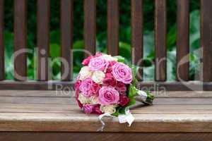beautiful bridal bouquet lying on the wooden benches
