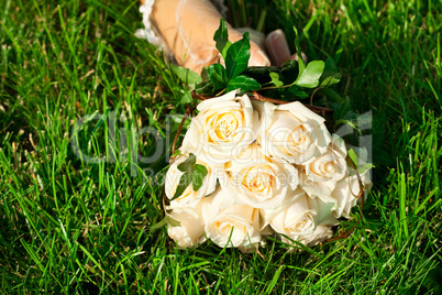 bridal bouquet to the bride's hand lying on green grass