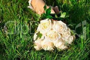 bridal bouquet to the bride's hand lying on green grass