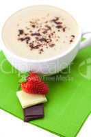 cappuccino cup strawberries and chocolate chips on a green cloth